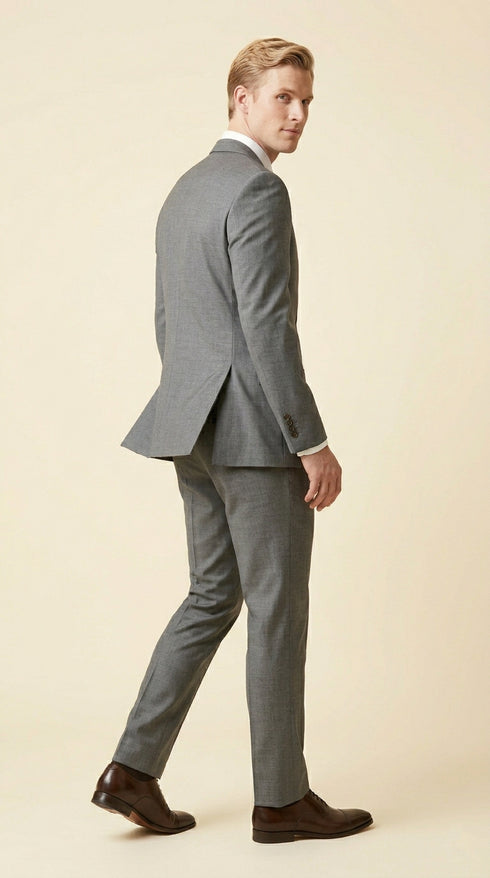Man wearing the F.Ferrante FEU230 tailored two-button suit in grey, styled with a white shirt, charcoal tie and dark brown Oxford shoes